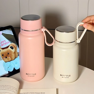 Minimalist stainless steel insulated water bottles in pink and cream with carry handles