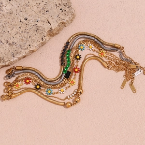 Détail macro du bracelet en or 18 carats avec pendentifs marguerites et zircons colorés