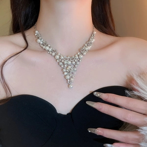 Détail du collier de perles et diamants de luxe en V porté par le mannequin