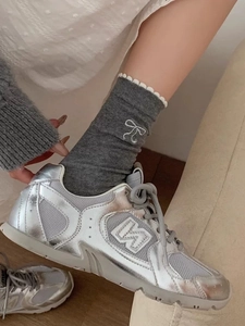 Silberne Retro-Sneaker kombiniert mit grauen Socken mit Spitzenschleifenstickerei