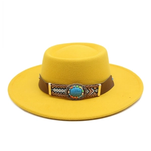 Detailed close-up of a mustard felt fedora with turquoise bead and ethnic woven band