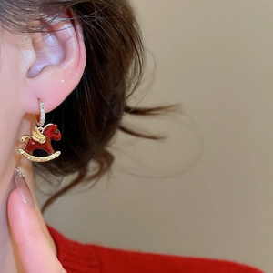 Détail de la boucle d'oreille cheval à bascule émail rouge avec dorure et zircons