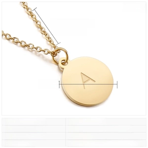 Détail macro du pendentif rond en acier inoxydable doré avec lettre A gravée et chaîne