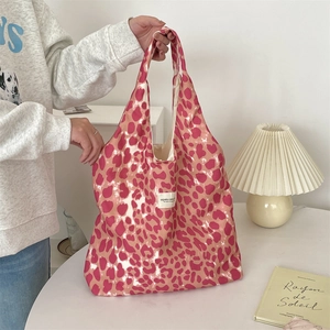 Close-up of pink leopard canvas tote bag with a minimalist woven label detail