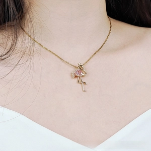 Macro view of pink flamingo pendant necklace in gold-plated steel with zircons