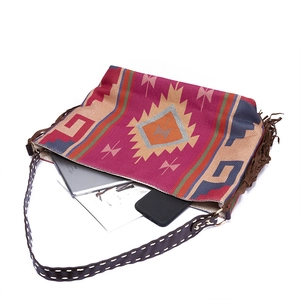Macro detail of Bohemian woven tote with colorful patterns and brown tassels showing high capacity