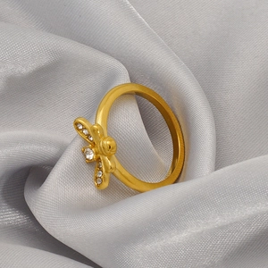 Elegant gold butterfly ring with micro-pave white cubic zirconia on gray satin fabric