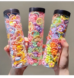 Detailed view of three jars with colorful elastic hair ties in flower and bow shapes