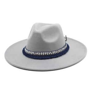 Detail of grey wool felt fedora featuring ethnic blue and gold woven band with fringe