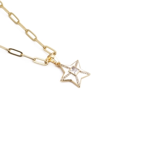 Golden star pendant necklace with cubic zirconia and paperclip chain on white background