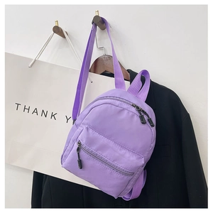 Detail view of purple nylon mini backpack with double zippers and adjustable straps