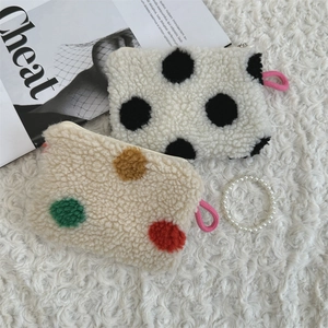 Detailed texture of plush heart-themed makeup pouches with stylish polka dot patterns