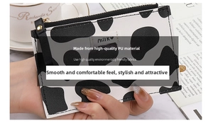 Detail of compact cow print PU leather coin purse with milk logo and gold zipper