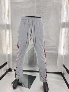 Detail of grey joggers with red side snaps and stylish plaid fabric patchwork accents