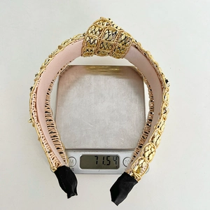 Detail showing the heavy gold braided texture and knot design of this wide fashion headband