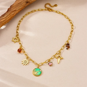 Gold stainless steel necklace with green sun pendant and star charms on beige surface