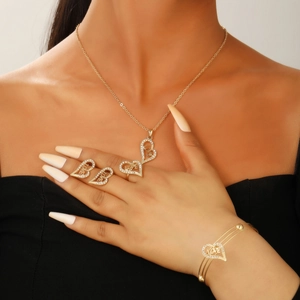 Close-up of gold plated hollow heart jewelry set with LOVE and BABY lettering