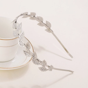 Elegant silver baroque leaf headband with realistic laurel design on white ceramic cup