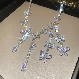 Close-up of sparkling silver butterfly and teardrop jewelry set in a gift box