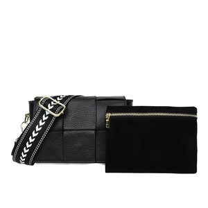 Detail of black woven leather shoulder bag with decorative strap and matching pouch