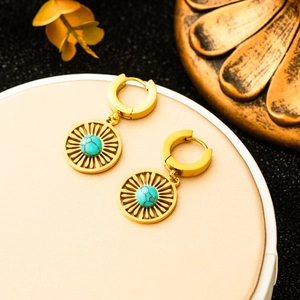 Golden round drop earrings with hollow radial pattern and turquoise center bead decoration