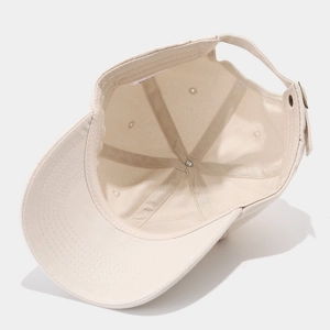 Detail of adjustable metal buckle and inner sweatband on beige cotton baseball cap