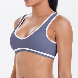 Détail de vue latérale d'un soutien-gorge de sport bleu-gris avec bordure blanche sur modèle