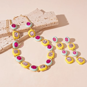 Colorful geometric jewelry set with pink and purple crystals in gold finish