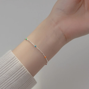 Detailed view of s925 silver rainbow bead bracelet on woman's wrist in minimalist style