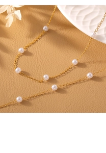 Elegant pearl necklace with gold chain on brown leather with white dried flowers