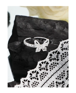 Macro detail of silver S925 butterfly ring with hollow wings and wrinkled texture