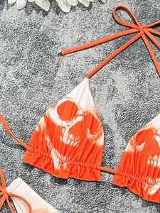 Detail of orange and white tie-dye bikini top with skull print and ruffle edges