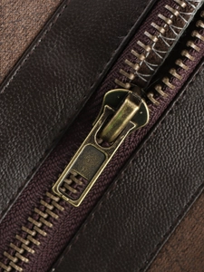 Macro shot of brown leather texture and antique bronze metal zipper on a fashion vest