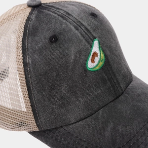 Close-up of realistic avocado embroidery on washed cotton and mesh trucker baseball cap