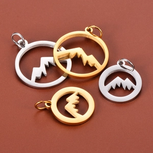Detailed macro view of gold and silver hollow mountain pendants in two various sizes