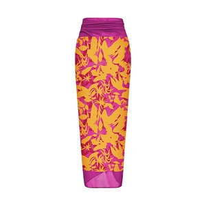Detail of bright pink and orange tropical leaf print on a long high-waisted wrap skirt