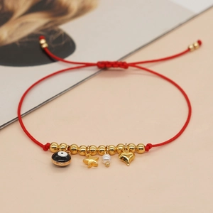 Red braided friendship bracelet with gold evil eye, star, heart, and pearl charms