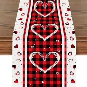 Red plaid Valentine's Day table runner with hand-drawn white hearts on wood background