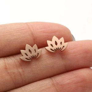 Close-up of rose gold hollow lotus stud earrings held on fingertips to show small size