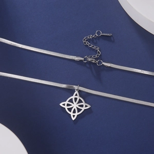 Close-up of silver stainless steel flat snake chain with intricate witch knot pendant