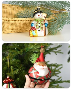 Detail of hand-painted glass snowman with glitter and Santa Claus bauble ornaments
