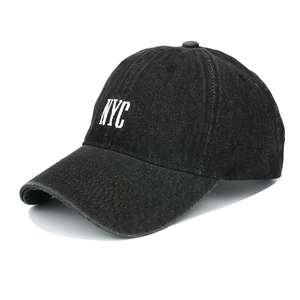 Detail of white NYC embroidery on black washed denim baseball cap with textured stitching
