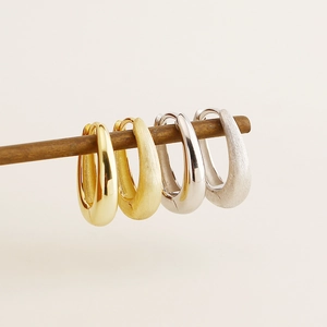 Close-up of S925 silver hoop earrings with brushed and polished metallic textures