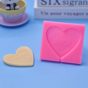 Pink heart-shaped silicone lollipop mold with LOVE embossing for DIY cake baking