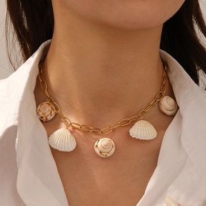 Golden stainless steel necklace with shell and conch pendants on model's neck
