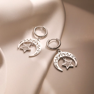 Silver plated moon and star drop earrings with sparkling zircon on silk background