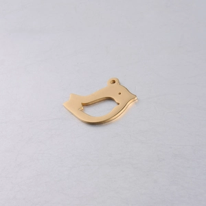 Macro detail of golden bird-shaped pendant with minimalist hollow cutout design