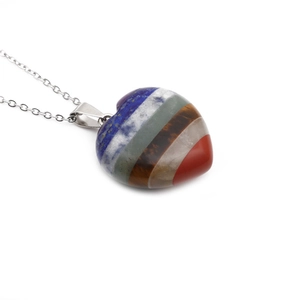 Macro view of multi-color striped heart-shaped stone pendant with silver metal chain