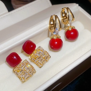 Vue macro détaillée de boucles d'oreilles vintage en zircon rouge et alliage doré en boîte