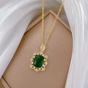 Vue détaillée du collier avec pendentif émeraude sur boîte à bijoux avec tissu en soie blanche